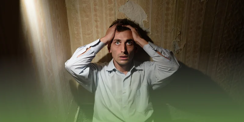 Мужчина в состоянии острого психоза сидит на полу